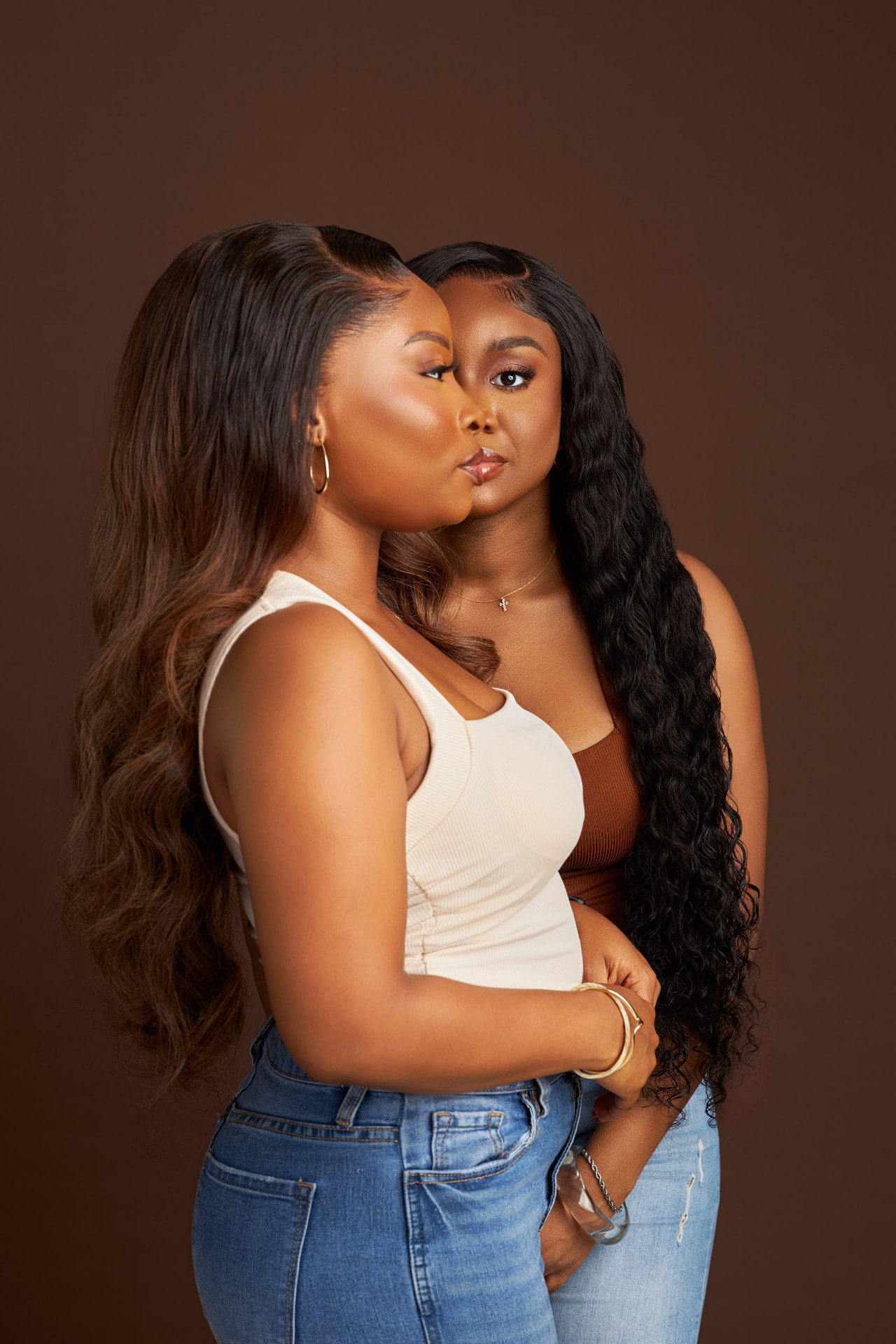 Two women wearing long wavy WigHub wigs